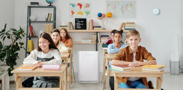 Students in a bright classroom with an air purifier running